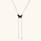 Wooden butterfly pendant necklace with cascading silver-toned chains on adjustable chain, available in amber and black.