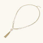 Long gold-plated necklace with freshwater pearls, chunky chain links, and flowing tassel pendant